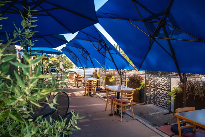 The sunny patio under blue umbrellas