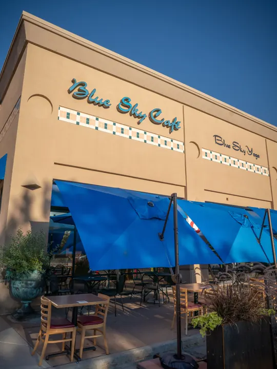 Blue Sky Cafe's storefront and patio with blue umbrellas