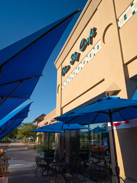 Blue umbrellas along the side of the Blue Sky Cafe building
