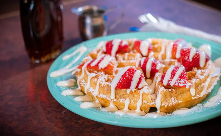 A stack topped with fresh strawberries and cream